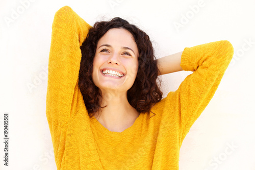 Close up happy young woman smiling with hands behind head © mimagephotos