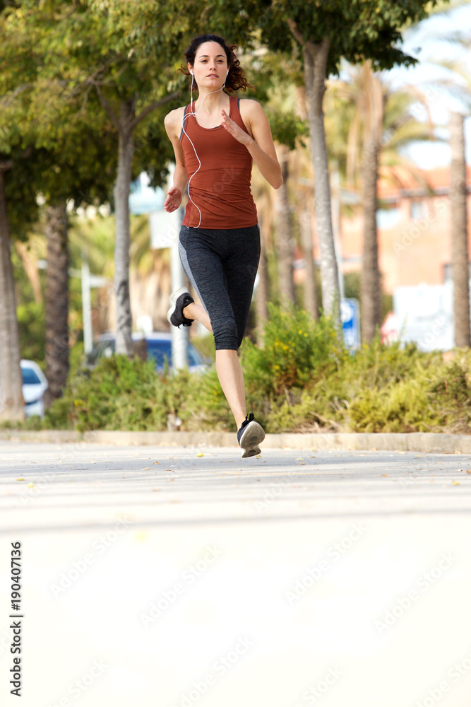 Full length young woman running outdoors