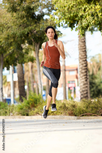 Full body healthy young sports woman running outdoors