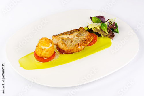 fried fish sauce tomatoes appetizer greens on a plate