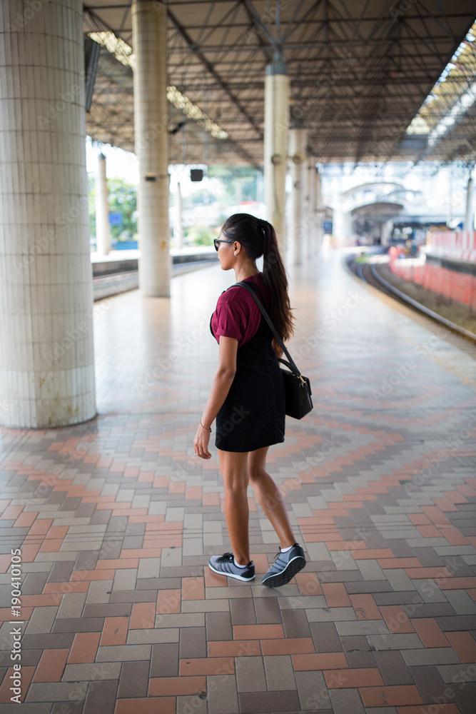 Young girl at a city train station. Young girl at a city train station.
