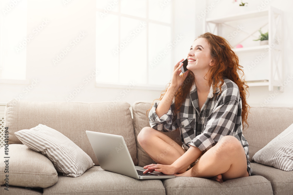 Girl with laptop and mobile sitting on beige couch. Girl with laptop and mobile sitting on beige couch.