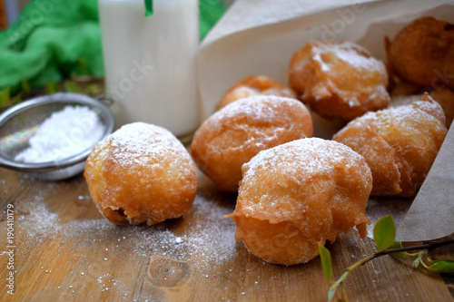French doughnuts Beignet covered with sugar powder on a wooden table
