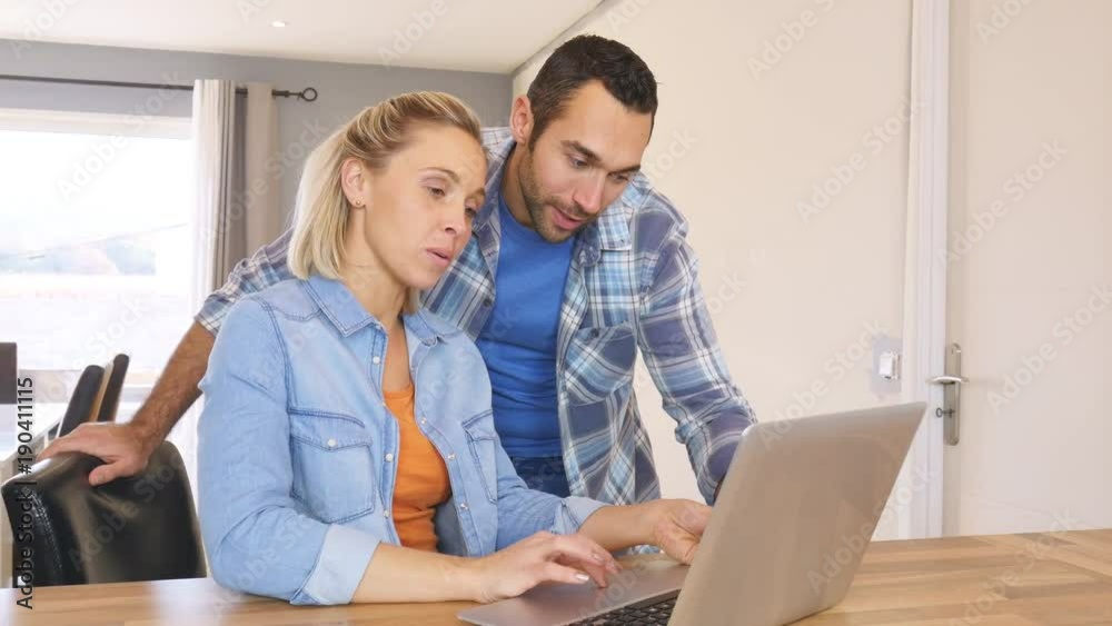 cheerful young couple at home shopping and buying online on internet with laptop computer cheerful young couple at home shopping and buying online on internet with laptop computer