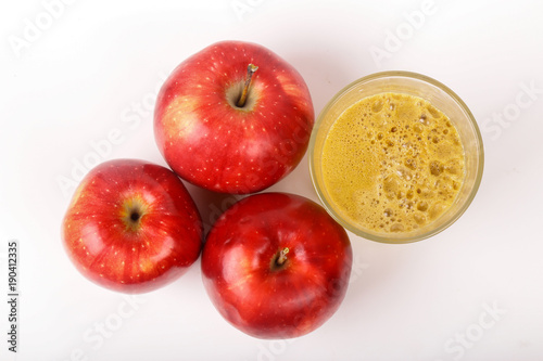 Red apples and a glass of fresh juice isolated on white background