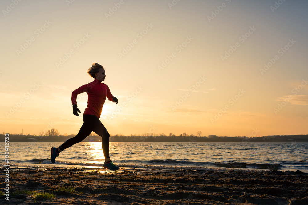 Woman beach running silhouette sunrise, lake coastline