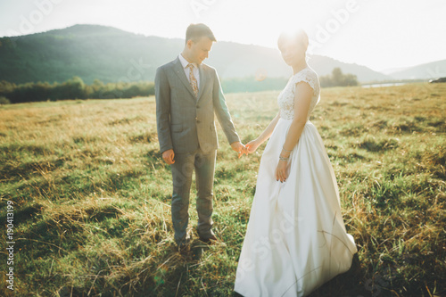 Beautiful wedding couple  love on the sunset. Fielf with view on mountains