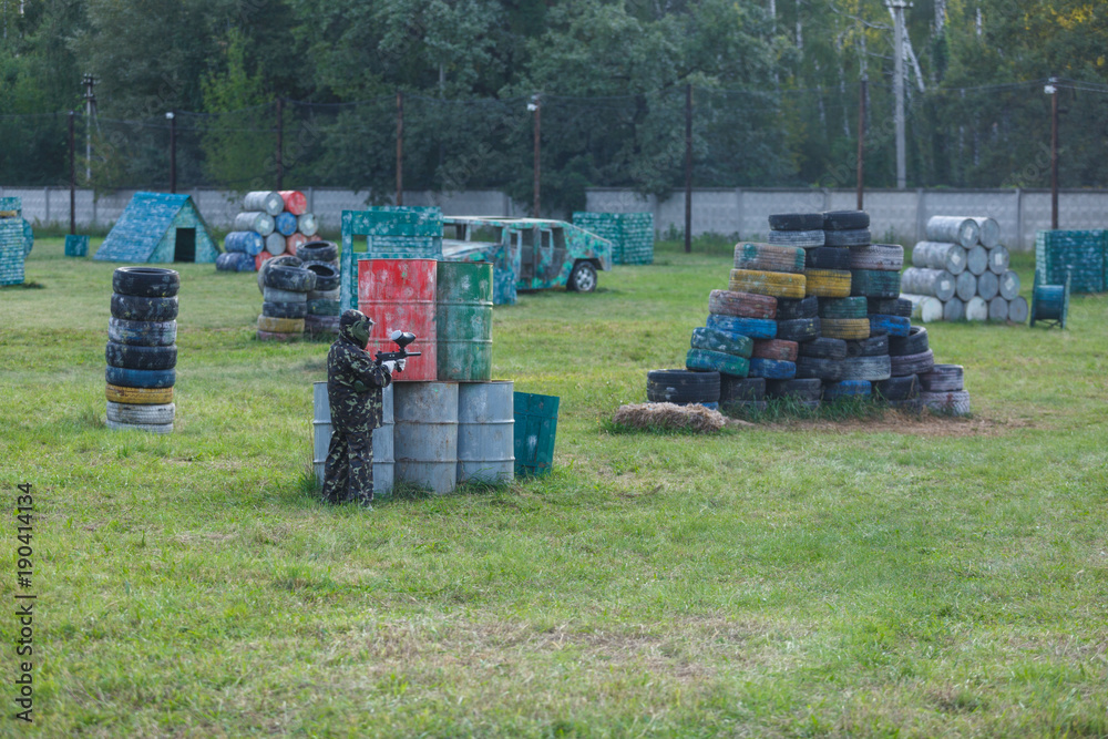 Boy in camouflage form with gun on the field. Children play paintball on the field. Sport, active lifestyle for kids Boy in camouflage form with gun on the field. Children play paintball on the field. Sport, active lifestyle for kids