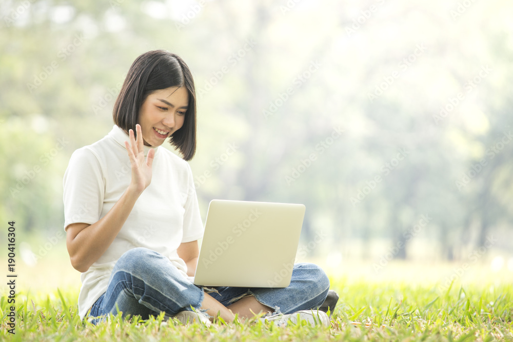 Asian Woman using laptop with attractive smiling at garden. People lifestyle concept. Asian Woman using laptop with attractive smiling at garden. People lifestyle concept.