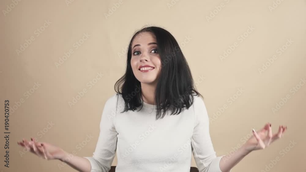 a young beautiful cute brunette on a beige orange background showing oops, Oh, accidentally, not guilty emotions a young beautiful cute brunette on a beige orange background showing oops, Oh, accidentally, not guilty emotions