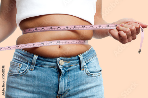 Overweight woman with tape measure around waist