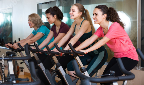 Elderly and young women working out hard in sport club