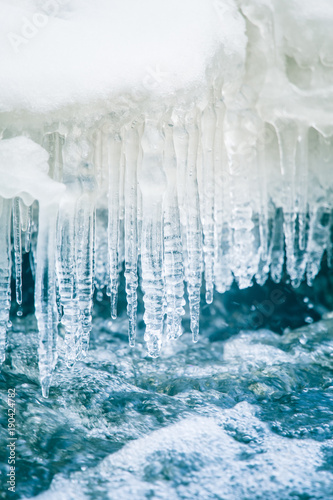 A beautiful frozen icicles at the bank of river in Latvia. Beautiful winter scenery. © dachux21