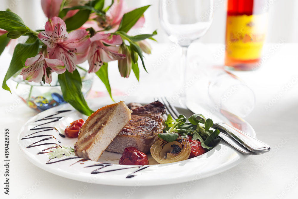 Succulent thick juicy portions of grilled fillet steak served with tomatoes and roast vegetables Succulent thick juicy portions of grilled fillet steak served with tomatoes and roast vegetables