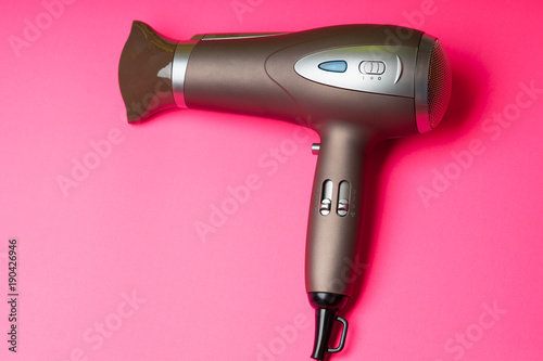 Hair dryer on a pink color background
