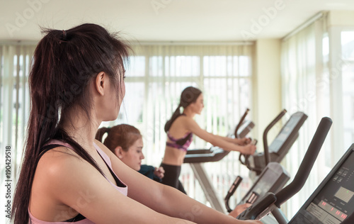 Photography Woman in fitness is looking at slimmer thinner woman working out