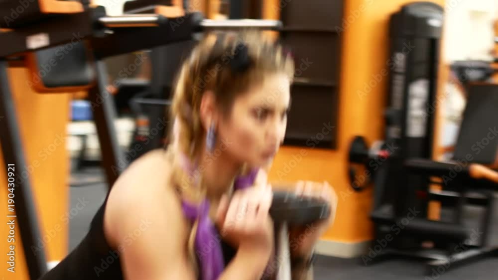 Young woman testing her strength. Sporty girl in the gym. Young woman testing her strength. Sporty girl in the gym.