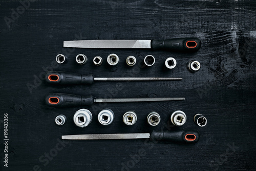 Set of tools chisel, wrenches on black wooden background photo