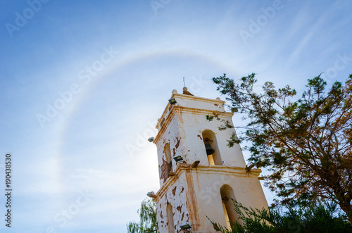 A sundog (halo) over bell tower and church in village Toconao close to San Pedro de Atacama in Atacama desert, Chile, South America photo