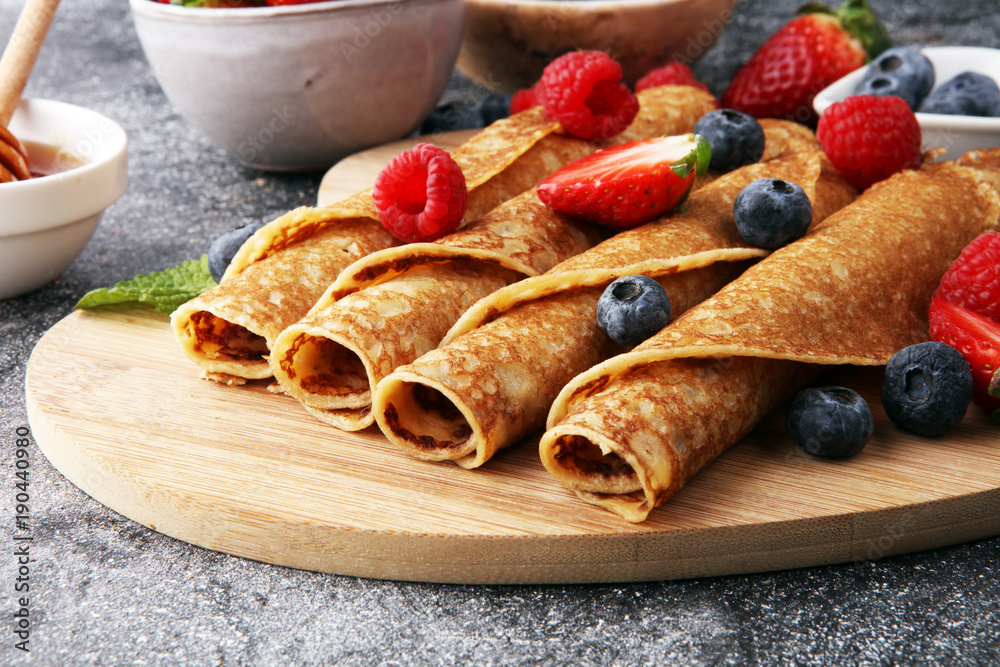 Delicious Tasty Homemade crepes or pancakes with raspberries and blueberries - obrazy, fototapety, plakaty 