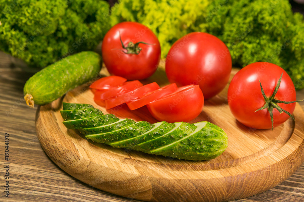 Fresh vegetables. Tomatoes and cucumbers on a wooden table Fresh vegetables. Tomatoes and cucumbers on a wooden table