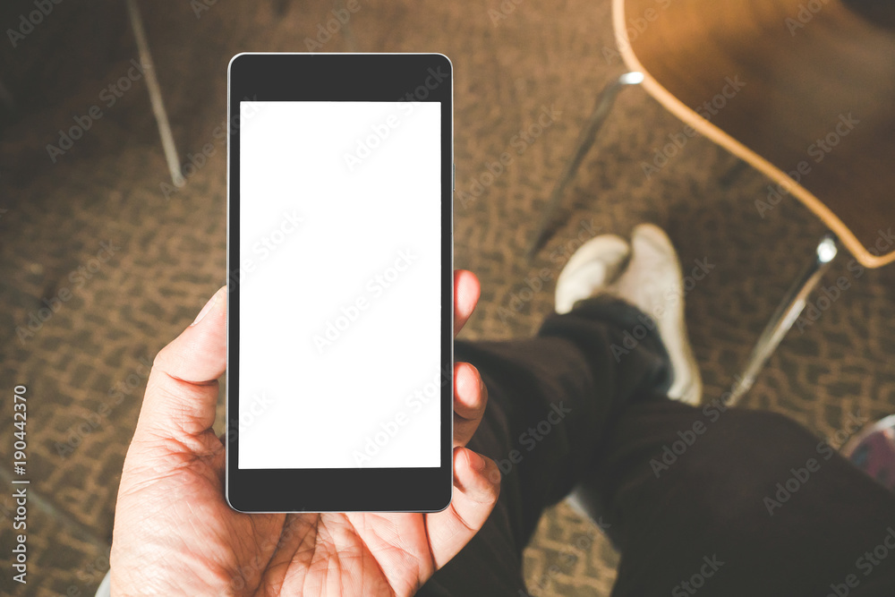 Hand holding black mobile smart phone with blank black screen in coffee ...