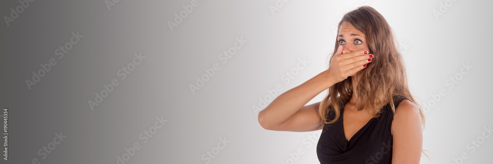 Beautiful girl with a hand on the mouth; isolated photo with copy space Beautiful girl with a hand on the mouth; isolated photo with copy space