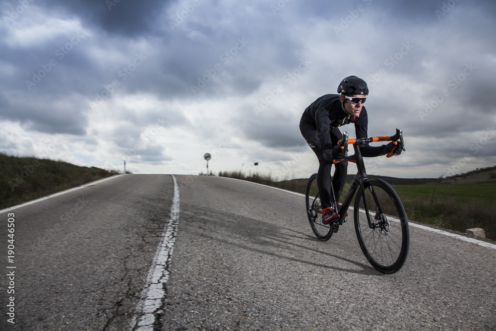 Fototapeta premium cyclist riding down the road