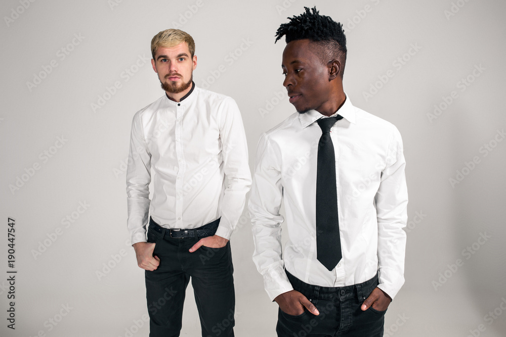 International friendship concept. Studio shot of two stylish young men on white background International friendship concept. Studio shot of two stylish young men on white background