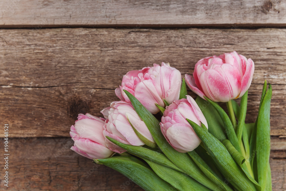 Bouquet of pink tulips over shabby wooden table. Spring greeting card happy mother day copy space