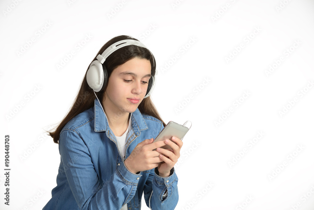 Fototapeta premium Young teenager with his headphones, listening to music through the mobile.