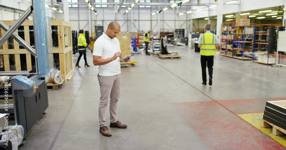 4k, Portrait of a young African American manager using digital tablet in warehouse. Slow motion. 4k, Portrait of a young African American manager using digital tablet in warehouse. Slow motion.