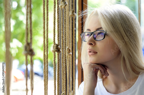 Beautiful blonde with glasses on a light background photo