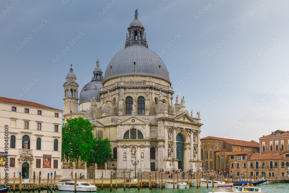 VENICE, ITALY - on May 5, 2016. View on Santa Maria della Salute church at sunrise.Tourists from all the world enjoy the historical city of Venezia in Italy, famous UNESCO World Heritage Site