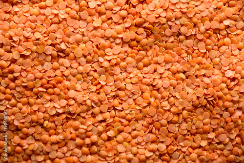 Red raw organic lentils texture. Food ingredient background. Top view