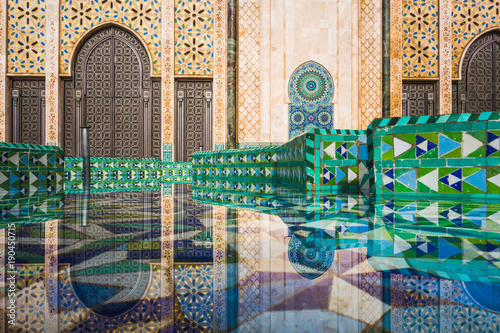 view of Hassan II mosque's big gate reflected on fountain water - Casablanca - Morocco