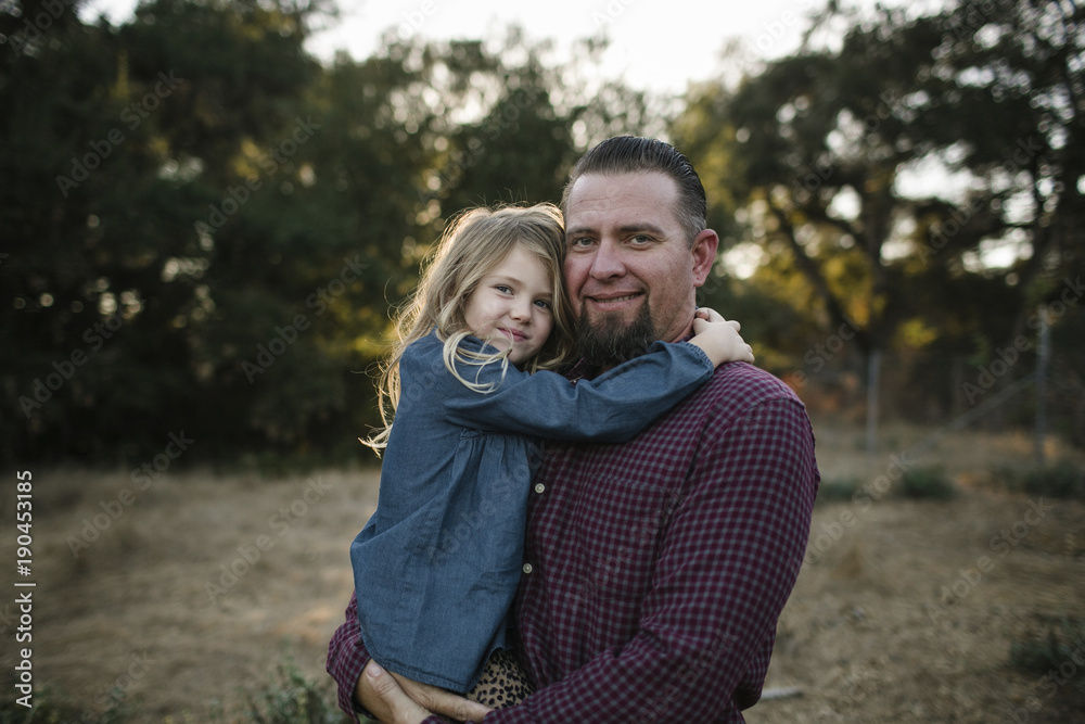 Portrait of smiling father and daughter standing in forest Portrait of smiling father and daughter standing in forest
