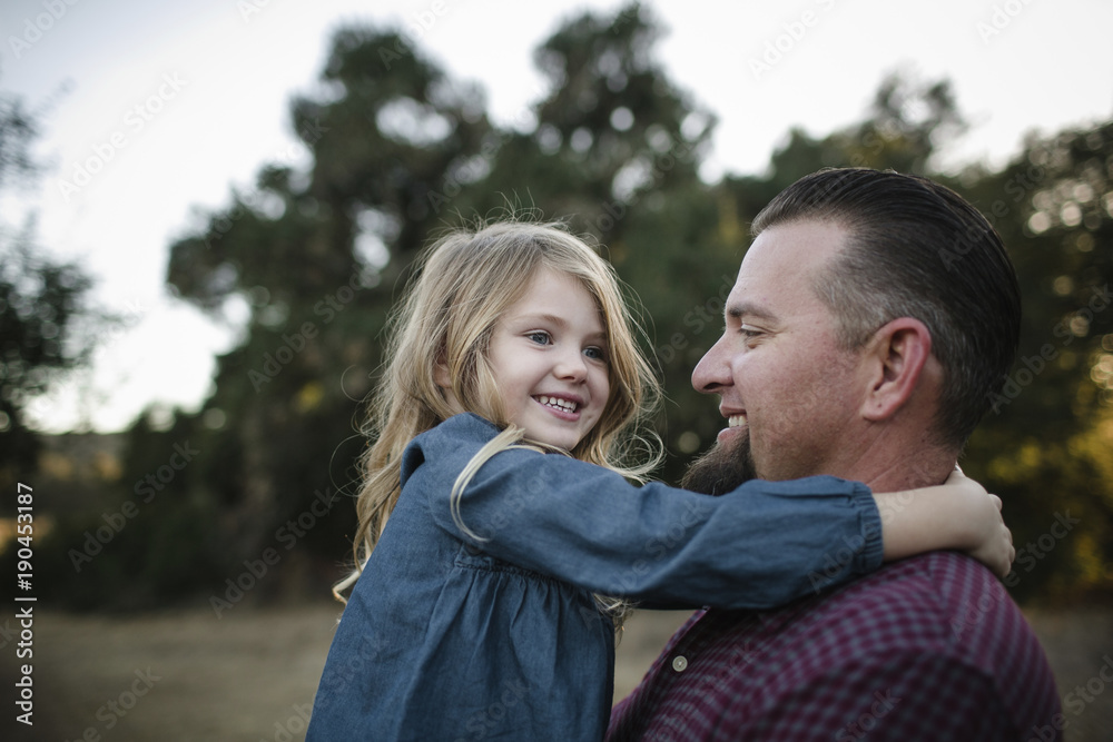 Cheerful father and daughter playing on field