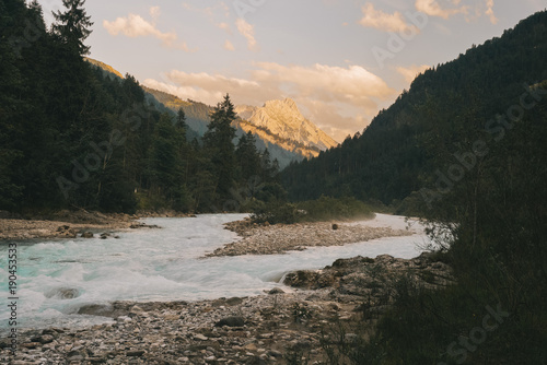 Scenic view of river flowing against cloudy sky in forest photo