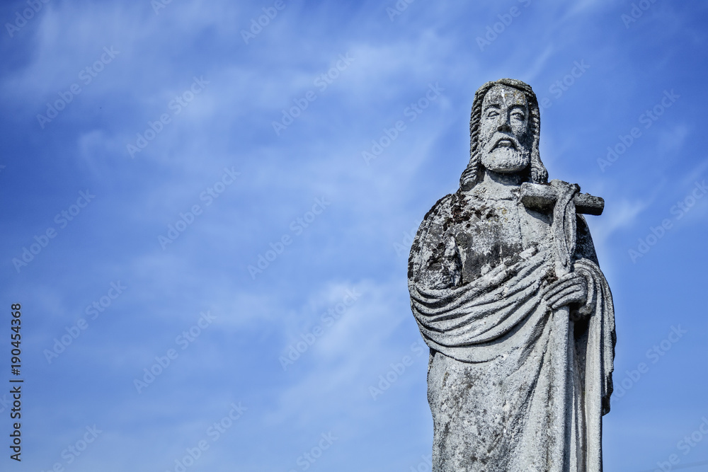 Obraz premium Jesus Christ ancient statue against the background of a blue sky