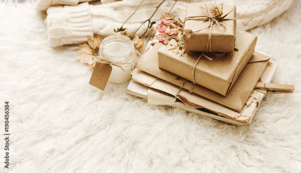 Wrapped craft gift boxes with dry flowers over fur background. Vintage toning image Wrapped craft gift boxes with dry flowers over fur background. Vintage toning image