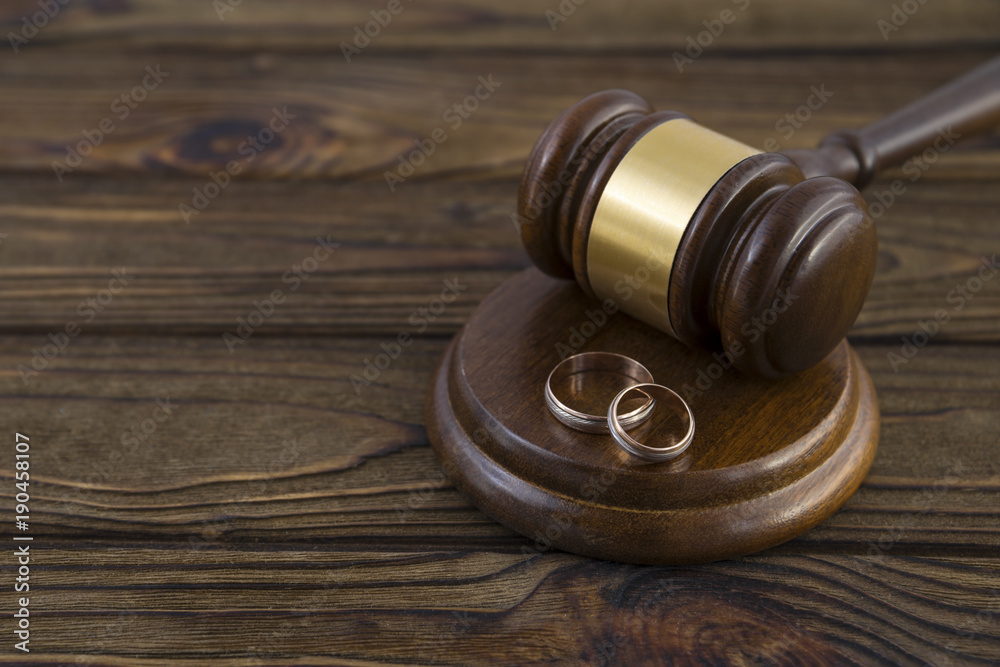 Wedding rings, hammer of the judge on a wooden background. The Divorce Process