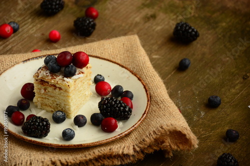 Piece of cake napoleon on a plate with sweet fresh berries