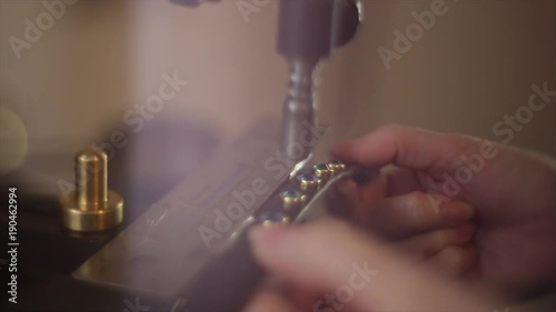 Stylized close up gemstones being set into a leather strap using a footpress. Shot with a dreamlike in-camera effect. photo