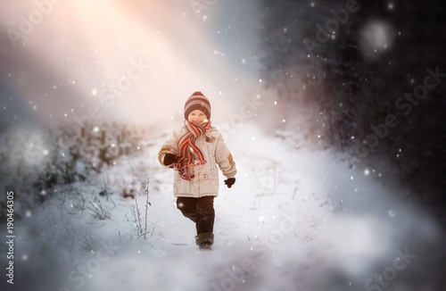 Happy young boy playing in snow
