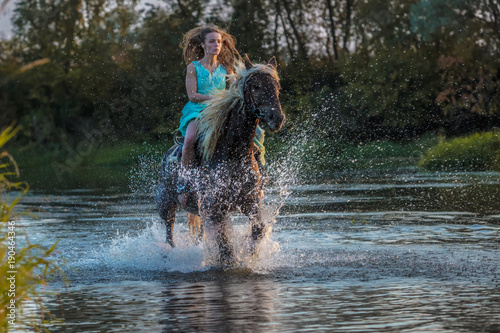 Fototapeta Naklejka Na Ścianę i Meble -  Girl riding horse on water surface