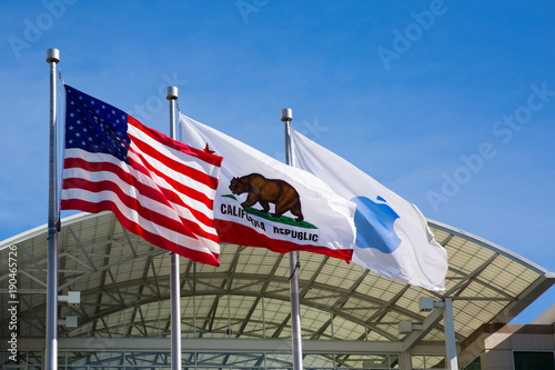 Flags in front of Apple headquarters: American, Californian and blue Apple flag