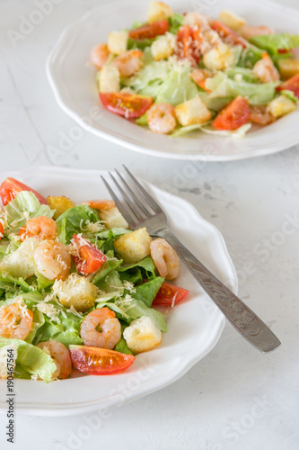 Caesar salad with shrimps on a white background