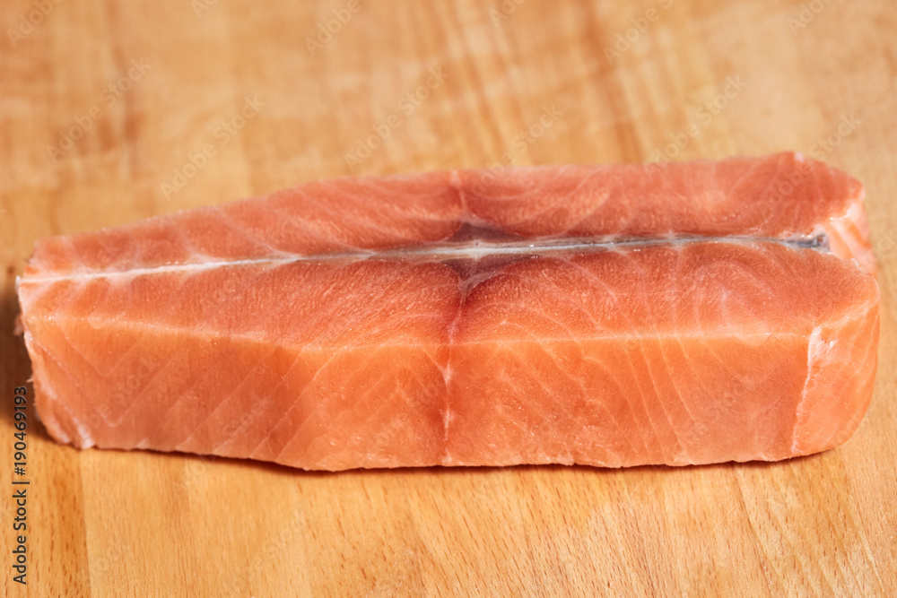 Salmon raw fish fillet on cutting wooden board Salmon raw fish fillet on cutting wooden board