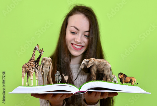 Canvas Print Girl holding open book of nature with animals.